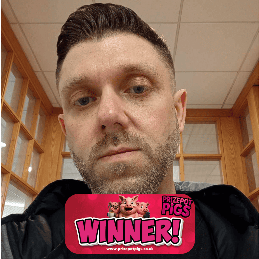 Man holding Prize Pot Pigs winner badge in a wooden room.